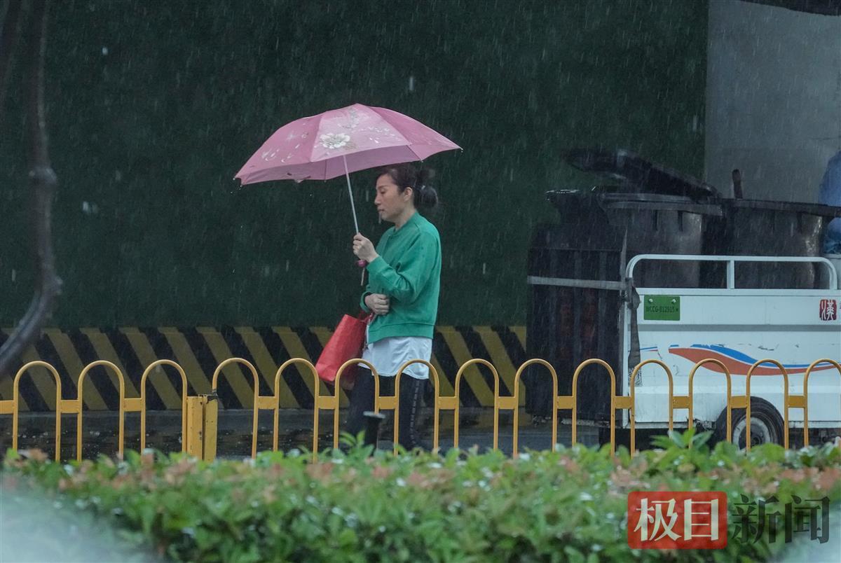 行人穿着毛衣在大雨中穿行（珞瑜路）