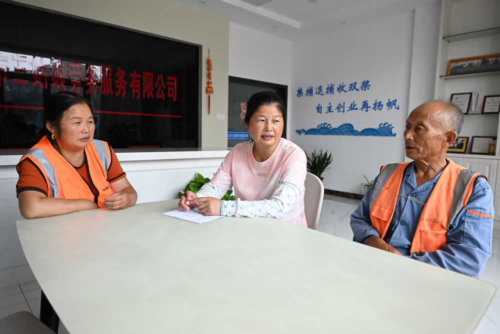 在安徽马鞍山市三姑娘劳务服务有限公司，陈兰香（中）和工作人员交流（2023年7月24日摄）。陈兰香是安徽省马鞍山市薛家洼的上岸渔民，在当地政府的帮助下，她和其他渔民合伙开办了劳务服务公司，主营保洁、绿化养护等服务。新华社记者 周牧 摄
