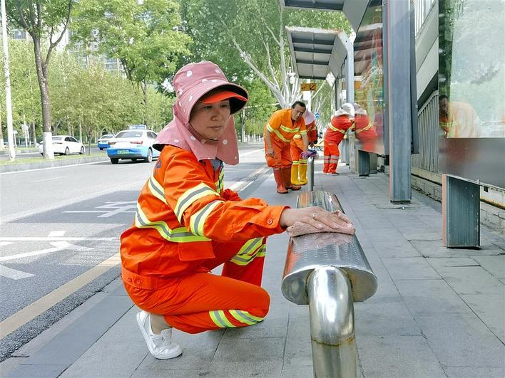 环卫工人擦洗公交站座椅 摄影：楚天都市报极目新闻记者卢成汉