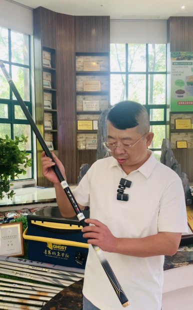 老鬼生物负责人向记者一行讲解鱼竿的商标故事。