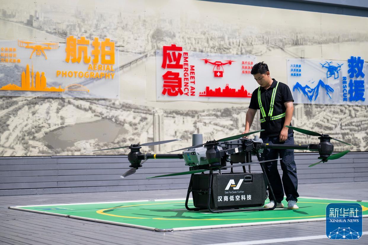↑ 6月16日，在汉商低空港停机坪，一名工作人员在起飞前检查无人机工作状态。
